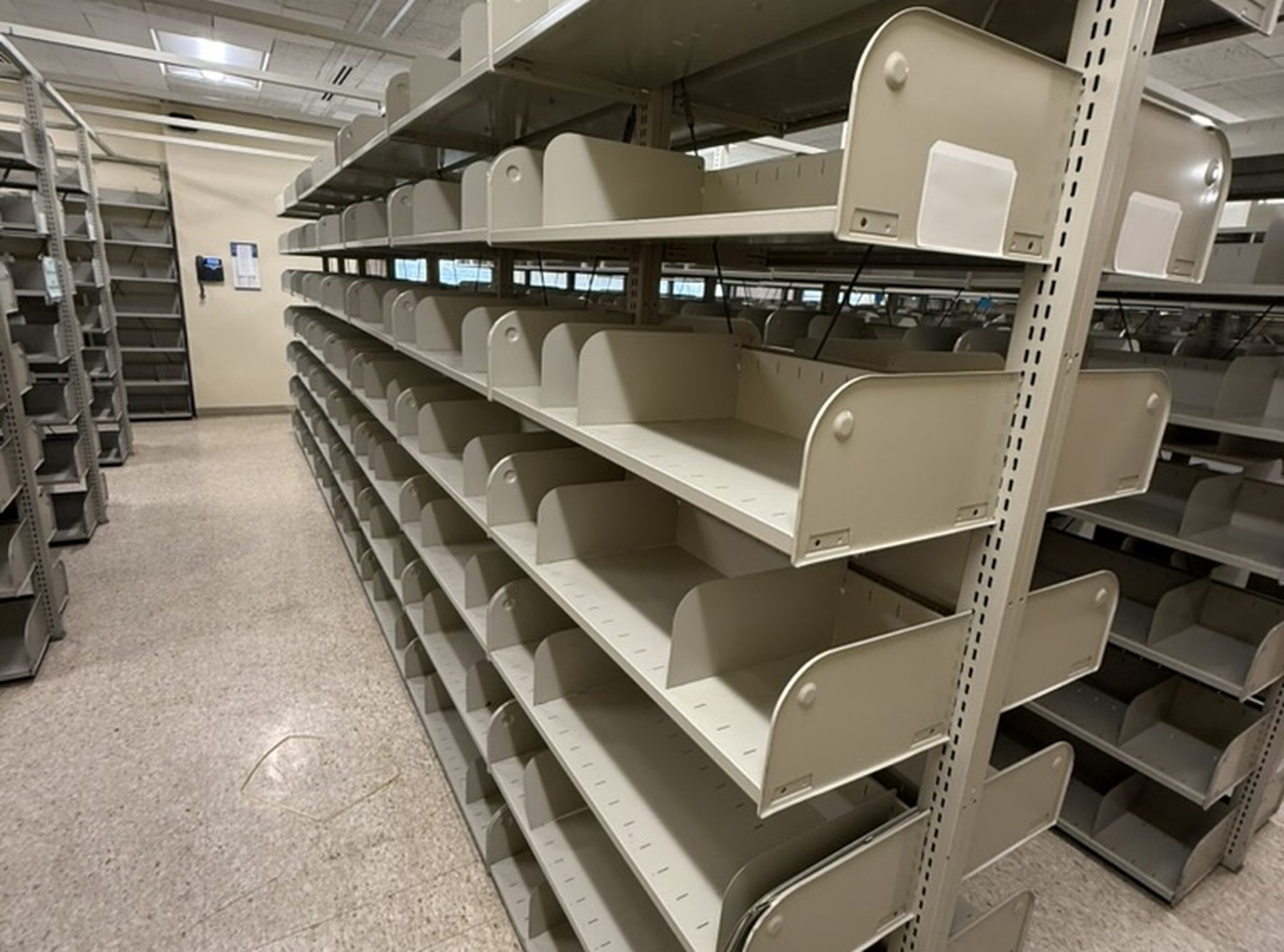 Metal shelving units emptied and staged for dismantling during a decommissioning project